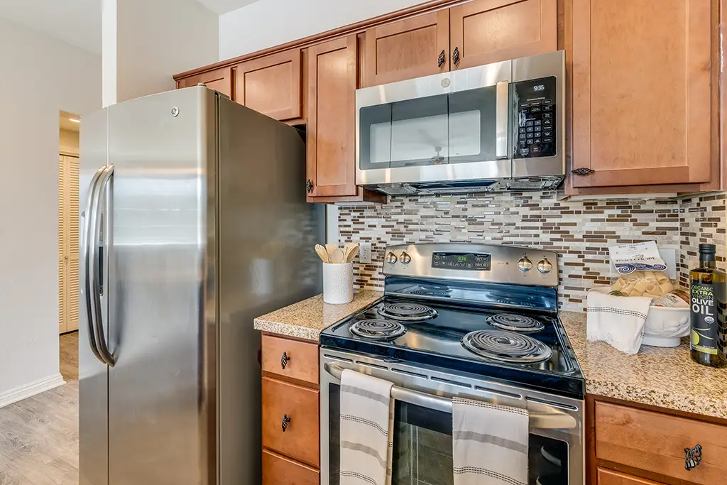 full kitchen with brown cabinetry and stainless steel appliances